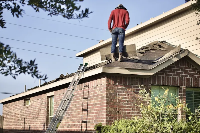 Professional roofer working on a residential roof in Hartland Run